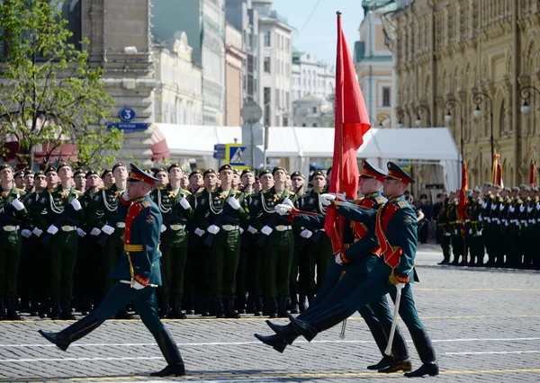 Militairen van de erewacht dragen de banner van de overwinning op de parade ter ere van de dag van de overwinning. — Stockfoto