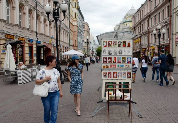 Неизвестные туристы смотрят художественные картины на пешеходной улице Арбат в Москве — стоковое фото