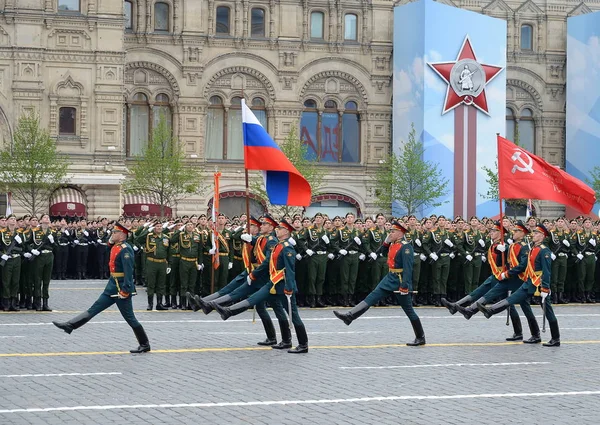 Солдаты почетного караула отдельного комендантского полка Преображения несут знамя Победы и российский флаг на военном параде на красной площади — стоковое фото