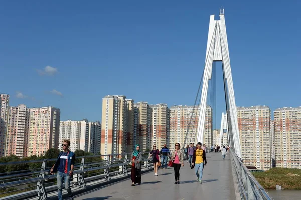As pessoas andam na ponte pedestre de Pavshinsky sobre o rio de Moscou em Krasnogorsk perto de Moscou — Fotografia de Stock