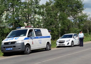  Yol devriyesi polis çalışanları durdurulan arabanın sürücüsünün belgelerini kontrol