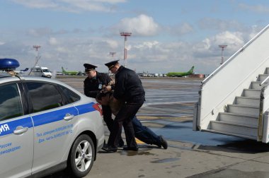 Moskova, Rusya - 26 Nisan 2018:Polis memurları uçak kavgacısını uçaktan indirdi