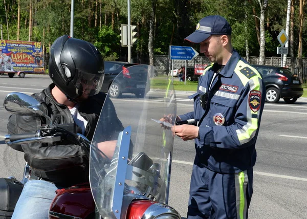 Inspektören för Road Patrol service av polisen checkar dokument till föraren av en motorcykel — Stockfoto