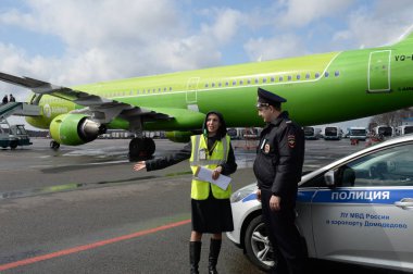 Moskova, Rusya - 26 Nisan 2018: Domodedovo Uluslararası Havaalanı'nda S7-Sibirya Havayolları'na ait Airbus A321 uçağında (kuyruk numarası Vq-Bqj) uçuş görevlisi ve polis memuru