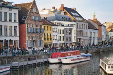 Gent, Belçika - 17 Şubat 2019: tarihi şehir binaları ile su kanalı, zevk tekneler. Alan gezinti yolu üzerinde yürüyen turist