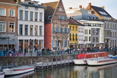 Gent, Belçika - 17 Şubat 2019: tarihi şehir binaları ile su kanalı, zevk tekneler. Alan gezinti yolu üzerinde yürüyen turist