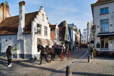 Bruges, Belçika - 17 Şubat 2019: Walplein kent muhteşem evleri, ortaçağ mimarisi. Atlı arabası