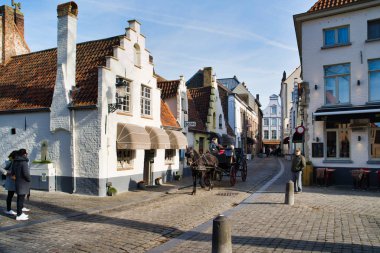 Bruges, Belçika - 17 Şubat 2019: Walplein kent muhteşem evleri, ortaçağ mimarisi. Atlı arabası