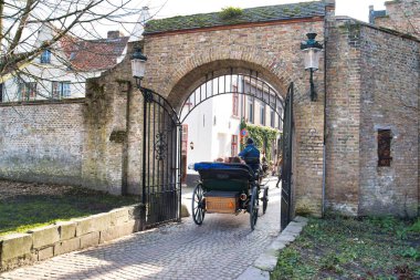 Bruges, Belçika - 17 Şubat 2019: bir at arabası ile bir at kapı girer