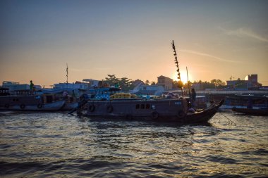 Can Tho, Vietnam - 28 Mart 2019: Mekong nehri boyunca gün doğumu-seyir delta ticaret teknelerde Mekong yüzen pazar. Bir ticaret gemisinin arka planında gün doğumu