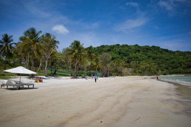 Phu Quoc adası, Vietnam - 31 Mart 2019: Dinlenmek için şezlong lar ve şemsiyelerle donatılmış beyaz kumlu bir plaj. Güney Çin Denizi'nin güzel sahili