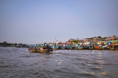 Can Tho, Vietnam - 27 Mart 2019: Mekong'un şafakvakti delta ticaret tekneleriyle yüzen pazarı Mekong Nehri'nde bir seyir. Nehir üzerindeki ayaklıklar üzerindeki evler