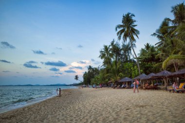 Phu Quoc adası, Vietnam - 30 Mart 2019: Dinlenmek için şezlong lar ve şemsiyelerle donatılmış beyaz kumlu bir plaj. Güney Çin Denizi'nin güzel sahili