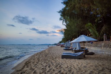 Phu Quoc adası, Vietnam - 30 Mart 2019: Gün batımında kumlu plaj. Rahat bir konaklama için şemsiyeler ve şezlonglar.