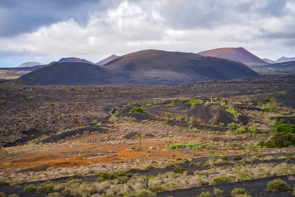 Beautiful views of the volcanic mountains and vineyards at the foot. The province of Las Palmas as part of the autonomous community of the Canary Islands, the island of Lanzarote. Mountains and clouds