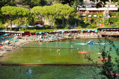 Paraggi, Liguria, İtalya - 15 Ağustos 2019: Rapallo ve Portofino şehirleri arasında Sandy Paraggi plajı. Avrupa'da bir tatil beldesinde tatil. Tigullio Körfezi'nde balıkçının eski köyü. Popüler turistik yer