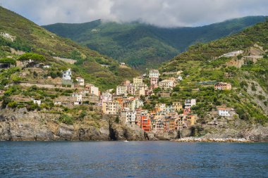 Riomaggiore, Cinque Terre, İtalya - 17 Ağustos 2019: Deniz kıyısındaki köy, kayalık sahilde renkli evler. Avrupa'da popüler bir tatil beldesi