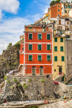 Riomaggiore, Cinque Terre, İtalya - 17 Ağustos 2019: Deniz kıyısındaki köy, kayalık sahilde renkli evler. Avrupa'da popüler doğa rezerv tesisi. Küçük plaj