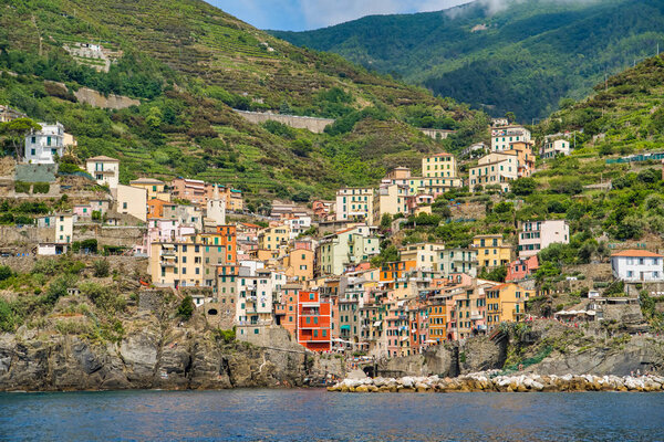 Riomaggiore, Cinque Terre, Italy - August 17, 2019: Village by the sea bay, colorful houses on the rocky coast. Nature reserve resort popular in Europe