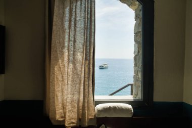 Deniz manzaralı bir oda, uzaktaki bir yelkenli teknesi Cinque Terre, İtalya