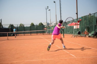 Forehand oynayan genç tenisçi