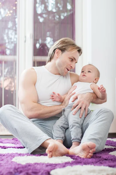 床に座って 彼の男の子と一緒に遊んで幸せな父 — ストック写真