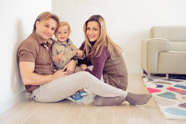 Mutlu bir aile küçük bebekleri ile yere oturma. Aile Evde oğulları ile vakit.