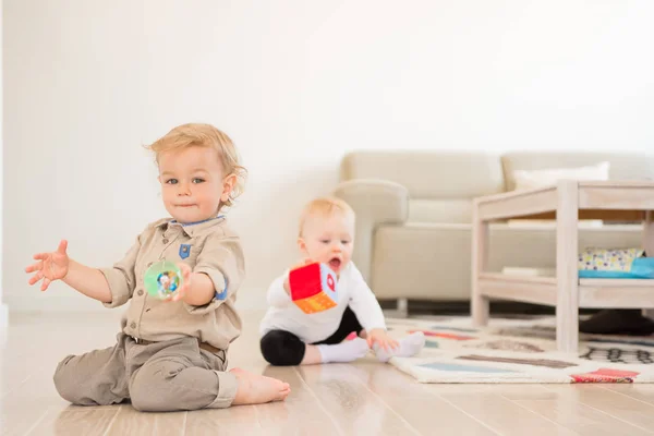 Симпатичная девочка и мальчик играют в игрушки дома — стоковое фото