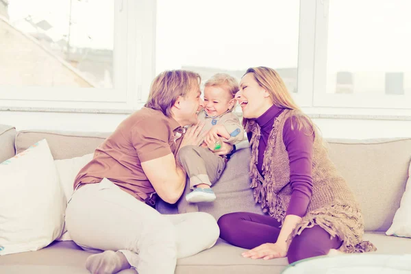 Ritratto di famiglia felice seduta sul divano e che gioca . — Foto Stock