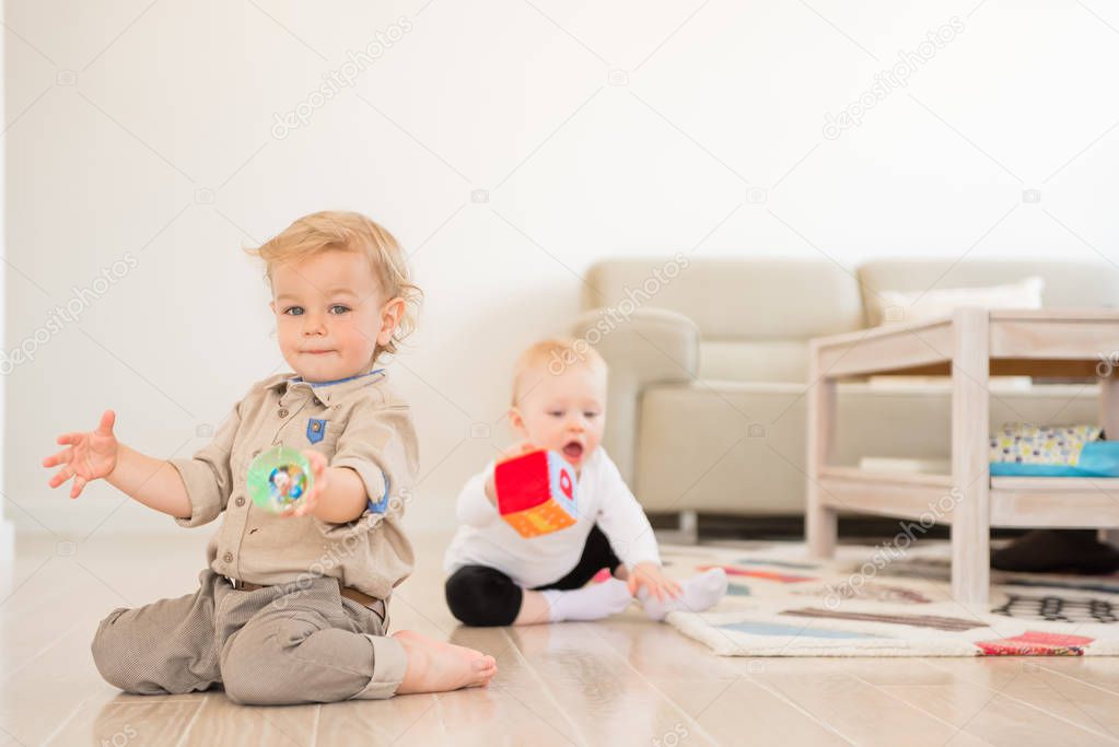 Cute little girl and boy playing with toys at home
