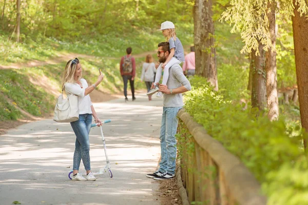 Madre che fotografa suo marito e sua figlia. Padre posa con la sua bambina . — Foto Stock