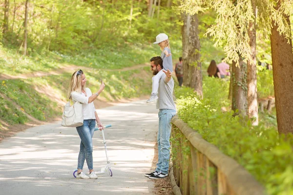 Mutter fotografiert ihren Mann und ihre Tochter. Vater posiert mit seinem kleinen Mädchen. — Stockfoto