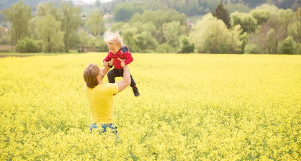Щаслива мати тримає свого маленького хлопчика в полі в красивий сонячний день — стокове фото