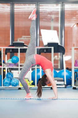 Güzel genç kadının gimnastics yerde yapması.