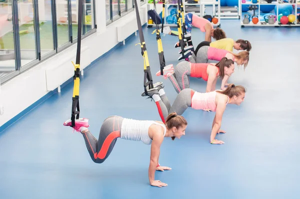 Trx üzerinde çalışma dışarı güzel genç kadın grubu. — Stok fotoğraf