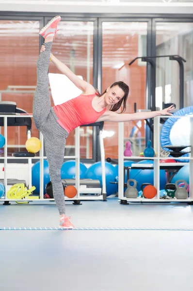 Mooie jonge vrouw doet gimnastics op de vloer. — Stockfoto