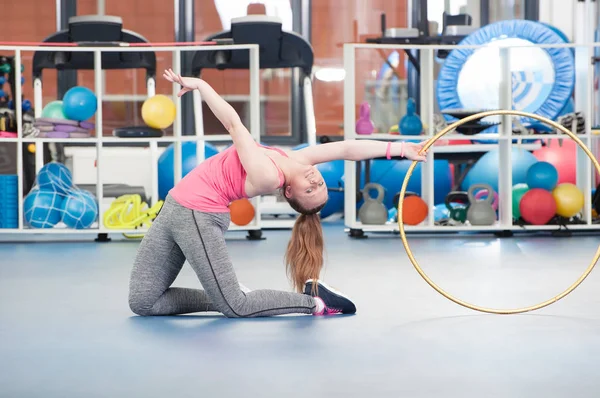 Schöne junge Frau macht Gimnastics auf dem Boden mit Reifen. — Stockfoto