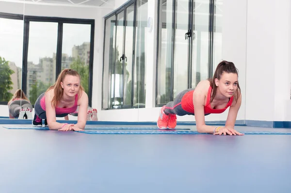 Twee mooie jonge vrouwen turnen oefening doet — Stockfoto
