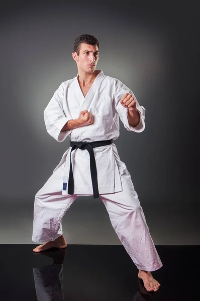 Guapo joven jugador de karate masculino posando sobre el fondo gris — Foto de Stock