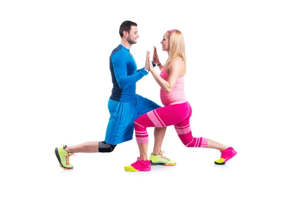 Happy young couple doing exercise in pair for pregnancy on the white background. — Stock Photo, Image