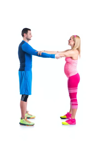 Feliz joven pareja haciendo ejercicio en pareja para el embarazo en el fondo blanco . — Foto de Stock