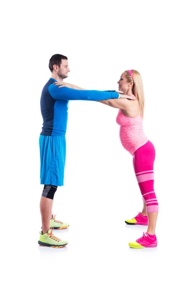 Feliz jovem casal fazendo exercício em par para a gravidez no fundo branco . — Fotografia de Stock