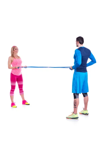 Happy young couple doing exercise in pair with elastic rubber for pregnancy on the white background. — Stock Photo, Image