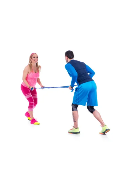 Feliz jovem casal fazendo exercício em par com borracha elástica para a gravidez no fundo branco . — Fotografia de Stock