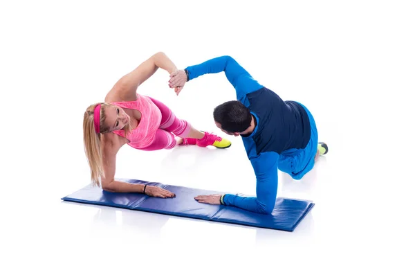 Feliz jovem casal fazendo exercício em par para a gravidez no fundo branco . — Fotografia de Stock