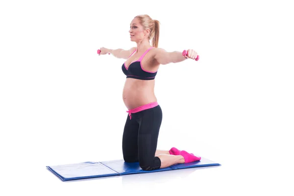 Piękne szczęśliwe kobiety w ciąży robi ćwiczenia z hantlami na białym tle — Zdjęcie stockowe