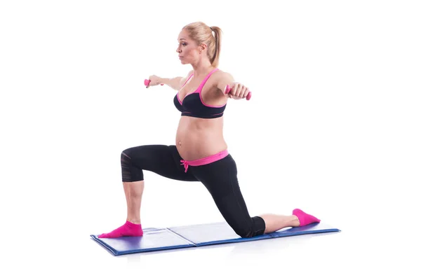 Belas mulheres grávidas felizes fazendo exercício com halteres no fundo branco — Fotografia de Stock