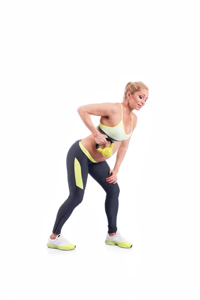 Belas mulheres grávidas felizes fazendo exercício com kettlebell no fundo branco — Fotografia de Stock