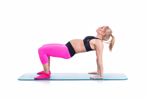 Счастливые беременные делают упражнения с матом на белом фоне — стоковое фото