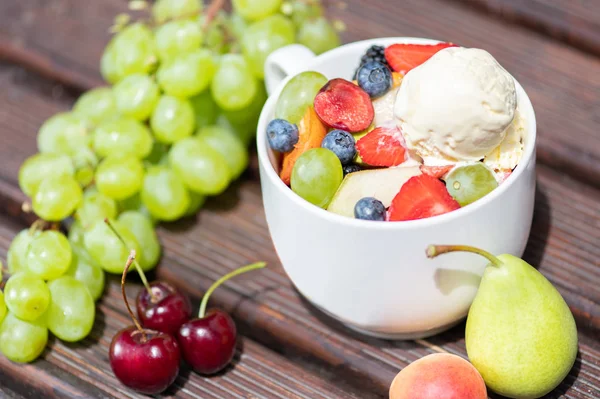 Ensalada de frutas frescas saludables con helado en el fondo de madera . — Foto de Stock